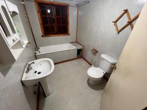 Baño pequeño con lavabo y aseo en Refugio Austral Ensenada, en Puerto Varas