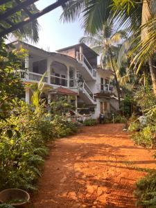 a house on the side of a dirt road at TGI Guest Houses in Calangute