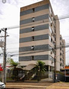 un grand bâtiment avec une clôture devant lui dans l'établissement Apartamento na melhor localização de Foz, à Foz do Iguaçu