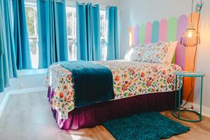 1 dormitorio con 1 cama y una ventana con cortinas azules en The Bluebird Cottage Style Cabin with Hot Tub near Turner Falls and Casinos en Davis