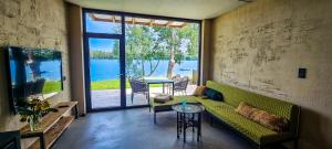 uma sala de estar com um sofá verde e uma mesa em Ferienhaus am See em Nordhausen