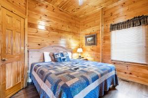 a bedroom with a bed in a wooden cabin at A Higher Calling, 1089 of FREE area attraction tickets for each paid day, Dollywood and More! in Pigeon Forge