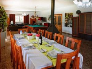 een eetkamer met een lange tafel met stoelen bij Aroeira Villa - Sea & Golf in Aroeira