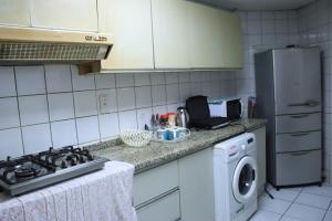 a kitchen with a stove and a refrigerator and a washing machine at Al Seef View in Dubai