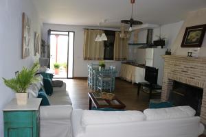 ein Wohnzimmer mit einer weißen Couch und einem Kamin in der Unterkunft LOS NOGALES in Cazalla de la Sierra