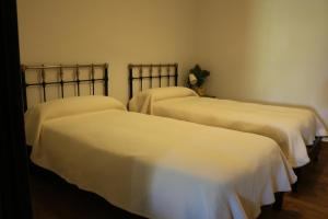 3 Betten in einem Zimmer mit weißer Bettwäsche in der Unterkunft LOS NOGALES in Cazalla de la Sierra