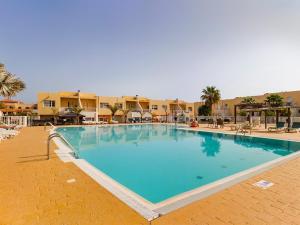 a large blue swimming pool in a resort at Castillo Holiday Home in Caleta De Fuste