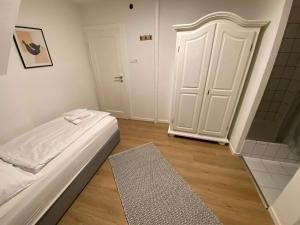 a bedroom with a bed and a shower and a door at Swan Rooms in Nuremberg