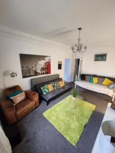 un soggiorno con 2 divani e un tappeto verde di Russell Square Apartment a Brighton & Hove