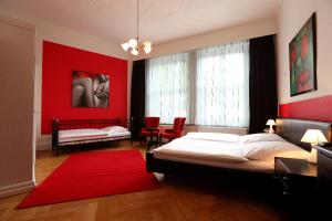 1 dormitorio con cama y pared roja en Hotel Amsterdam en Hamburgo