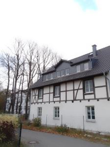a white house with a black roof at FEWO 4, Schloss-Park-Residenz, Lindenalle 23, 18230 Ostseebad Rerik OT Blengow in Rerik