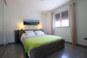 - une chambre avec un lit doté de draps verts et une fenêtre dans l'établissement Saardia, à Ahetze