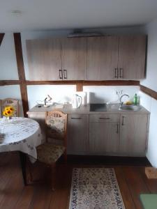 a kitchen with wooden cabinets and a table and a sink at FEWO 4, Schloss-Park-Residenz, Lindenalle 23, 18230 Ostseebad Rerik OT Blengow in Rerik