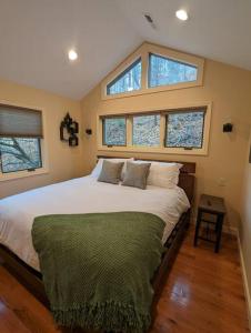 a bedroom with a large bed with three windows at Crows Nest Luxury Near Asheville in Marshall