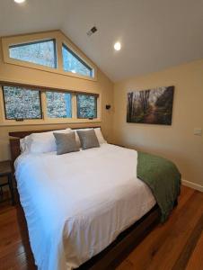 a bedroom with a large white bed with two windows at Crows Nest Luxury Near Asheville in Marshall