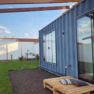 a blue tiny house with a bench next to it at Casa Container Blackhawk in Pirassununga