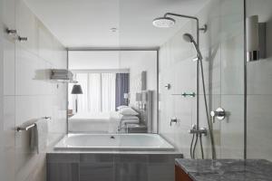a bathroom with a shower and a bath tub at Sheraton Melbourne Hotel in Melbourne