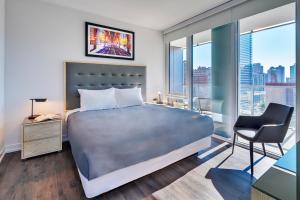 a bedroom with a bed and a chair and windows at Level Chicago Old Town in Chicago +20 photos