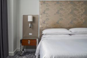 a bedroom with a bed and a nightstand next to a bed sidx sidx sidx at Sheraton Melbourne Hotel in Melbourne
