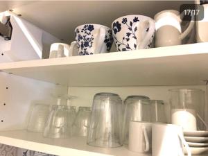 a shelf filled with glass jars and vases at Studio Confort centre ville in Bordeaux +4 photos