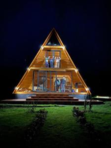 a large wooden house with people standing in the window at Hacienda El Rejo in Machachi