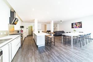 a kitchen and living room with a table and chairs at Maison Frappaz 4 chambres avec jardin Villeurbanne in Villeurbanne