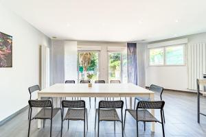 - une salle à manger avec une table et des chaises dans l'établissement Maison Frappaz 4 chambres avec jardin Villeurbanne, à Villeurbanne