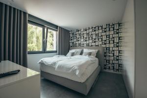 ein Schlafzimmer mit einem weißen Bett und einem Fenster in der Unterkunft Lenneapartments Premium in Plettenberg