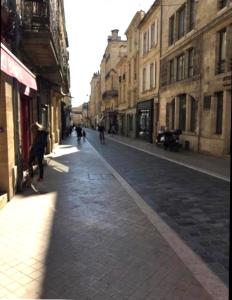 a city street with people walking down the street at Studio Confort centre ville in Bordeaux
