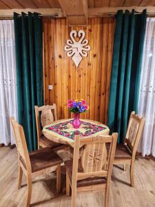 a dining room table with a vase of flowers on it at Pokoje u Dany Witów in Witów