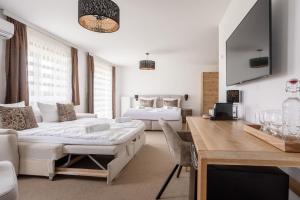 a living room with two beds and a table in a room at Casa Plus in Villach