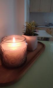 a candle on a wooden cutting board with a plant at Evaggelia's Apartments 1 Διαμονή στο κέντρο in Kozani