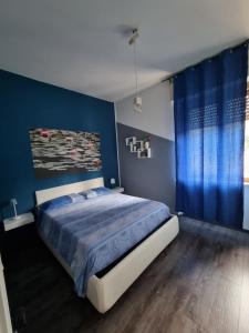 a bedroom with a large bed with blue walls at SPAZIO-CONFORT-FITNESS in Piombino