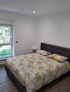 a bedroom with a bed and a window at Au fil de l'eau in Lapoutroie