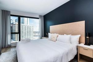 Schlafzimmer mit einem großen weißen Bett und einem großen Fenster in der Unterkunft Luxurious apartment great view Montreal Canada in Montreal