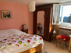 a bedroom with a bed with a flower quilt on it at Appartement montagne Le Revard in Pugny-Chatenod