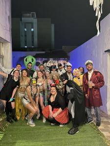 a group of people dressed in costumes posing for a picture at Bardot Hostel in Paraná