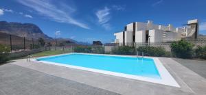 a large blue swimming pool in front of a building at Él Rome Duplex in Agaete