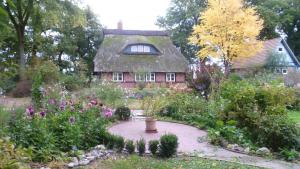 Schwanewede的住宿－Ferienhaus Siedschelje，鲜花屋前的花园