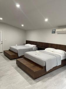 two beds are in a room with at Roaring River Golf & Accommodations in Belmopan