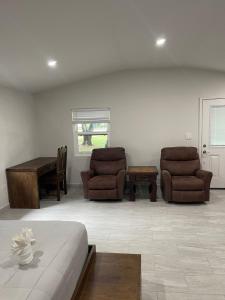 uma sala de estar com duas cadeiras e uma mesa em Roaring River Golf & Accommodations em Belmopan