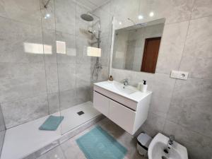 W białej łazience znajduje się umywalka i lustro. w obiekcie Paraiso 46 w mieście Parque Holandes