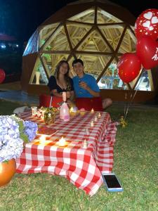 un homme et une femme assis à une table de pique-nique avec ballons dans l'établissement Greenlandomesa CUARZO, à La Honda