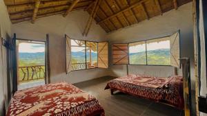 a room with two beds and windows with mountains at Hotel Rancho Maju in San Agustín +17 photos