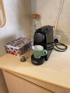 een koffiezetapparaat en een kopje op een aanrecht bij Bella Vita 43 - Porlezza in Porlezza