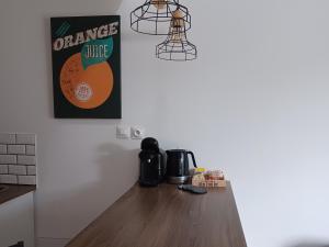 ein Schild mit Orangensaft an einer Wand in einer Küche in der Unterkunft Studio privé avec terrasse entrée indépendante in Saint-Nazaire