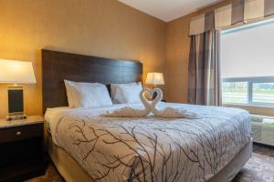 a bedroom with a bed with a swan statue on it at Best Western Plus South Edmonton Inn & Suites in Edmonton
