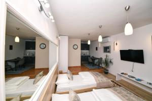サラエボにあるApartman Hrastovi Free Parkingのベッド3台、薄型テレビが備わる客室です。
