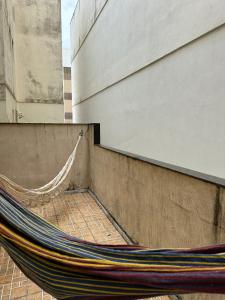 a hammock leaning against a wall next to a building at APARTAMENTO TOP, Conforto e Qualidade in Guarapari