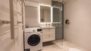 a bathroom with a washing machine and a sink at Villa Maija 4 Upperside in Hanko +12 photos